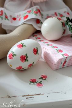 a doll sitting next to two eggs on a table