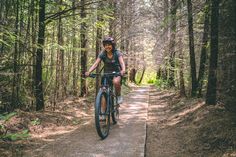 a person riding a bike on a path in the woods