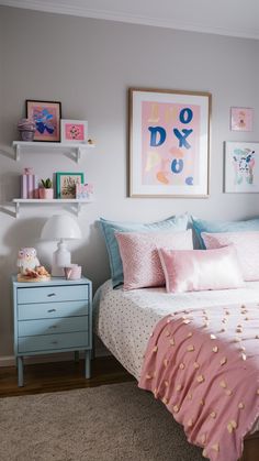 a bed with pink and blue pillows in a bedroom next to a painting on the wall