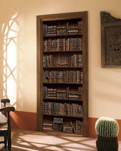 a bookshelf in the corner of a room next to a cactus