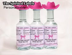 three empty bottles with pink bows on the top and one has a label for each bottle