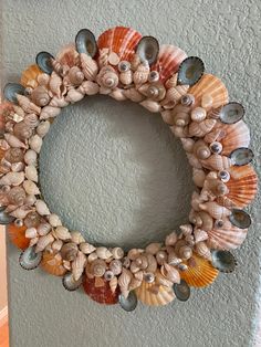 a wreath made out of seashells hangs on the wall