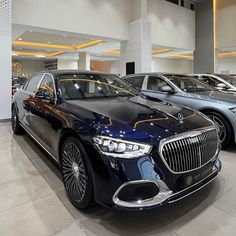 several luxury cars are parked in a showroom