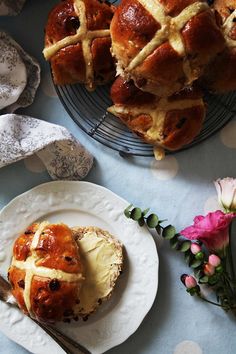 hot cross buns on plates with flowers and utensils