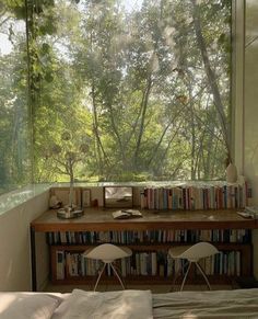 a bed sitting under a window next to a bookshelf filled with lots of books