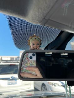 a person taking a photo in the rear view mirror of a car with their cell phone