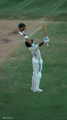 a cricket player holding his bat up in the air with one hand and two other hands