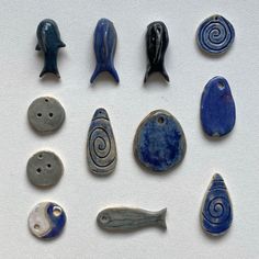 several different types of ceramic items on a white surface with blue and gray colors,