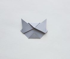 an origami cat on a white wall