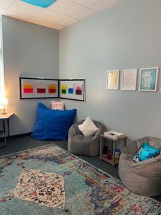 a living room filled with furniture and pillows on top of a blue carpeted floor