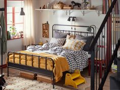 a bed sitting under a window next to a stair case