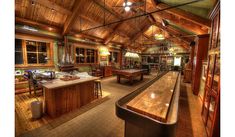 a large room filled with lots of wooden furniture and tables in front of a bar