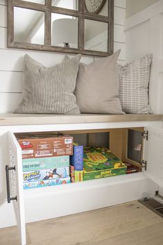 a shelf with books and pillows on it