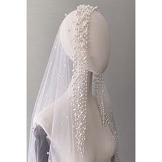 the back of a wedding veil with beaded details on it, sitting on top of a mannequin