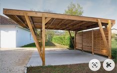 a wooden carport sitting in the middle of a yard