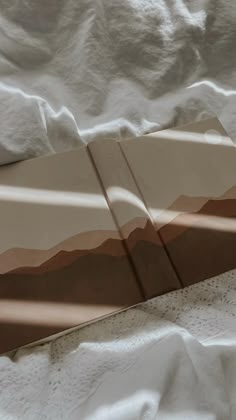 an image of a bed with white sheets and brown lines on the sheeted bedspread