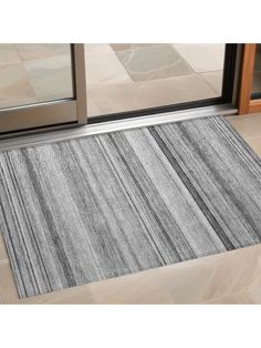 a door mat on the floor in front of a glass door with an entry way