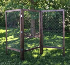 a wooden fence in the grass near a tree