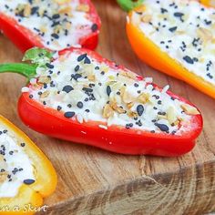 several peppers are stuffed with cheese and other toppings on a wooden cutting board, ready to be eaten