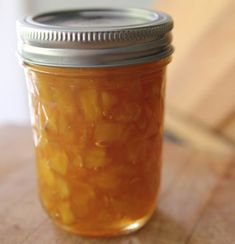 a glass jar filled with pickles sitting on top of a wooden table