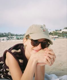 a woman laying on top of a sandy beach