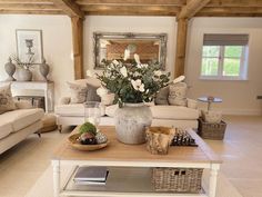 a living room filled with furniture and a large vase on top of a coffee table