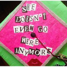 a pink and green graduation cap with the words she doesn't even go here anymore