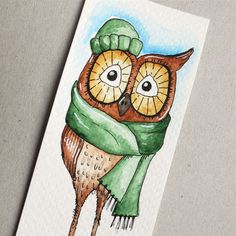 an owl with a green scarf and hat on it's head is wearing a green knitted cap