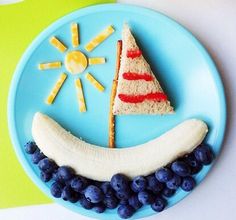 a blue plate topped with a slice of cake next to a banana and some grapes