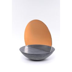 an orange and silver plate sitting on top of a white table