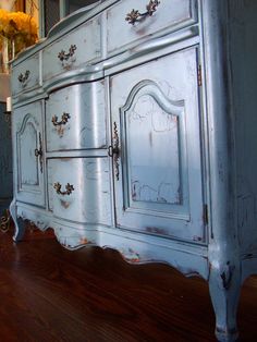 an old dresser is painted in blue and white