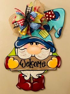 a welcome sign hanging on the wall with a gnome holding a sign that says welcome