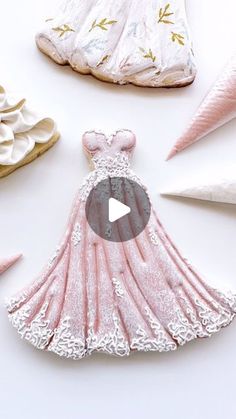 a dress made out of pink and white paper on top of some other things in the background