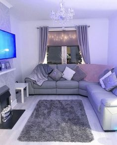 a living room filled with furniture and a flat screen tv mounted on the wall next to a fire place