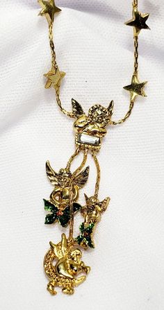 This is a such a pretty necklace. It has three dangling cherub, pixie charms and two have green enamel flowers. The one at the top has one single rhinestone.  The chain is adorned with a few stars and this is adjustable. This could possible be a Kirks Folly piece and the hang tag fell off. The clasp works and more modern of a piece than true vintage. Overall in good condition. See all photos for wear and sizing.  **PAYMENT IS DUE WITHIN 24 Hours OF THE AUCTIONS END** If you need more time, PLEASE CONTACT ME. If you have any problems with the items please let me know before leaving feed back and I will gladly remedy ANY situation. **Thank you!!!** Whimsical Star-shaped Party Jewelry, Cherub Angel, Antique Jewelry Necklace, Kirks Folly, Pretty Necklace, Gold Moon, Pretty Necklaces, Enamel Flower, Green Enamel