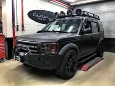 an suv is parked in a garage with its lights on