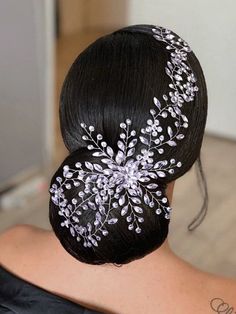 the back of a woman's head wearing a hair comb with flowers on it