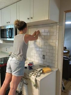 a woman standing on top of a kitchen counter