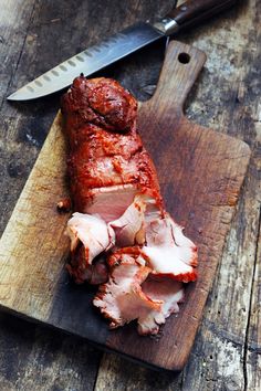 sliced meat sitting on top of a cutting board next to a knife