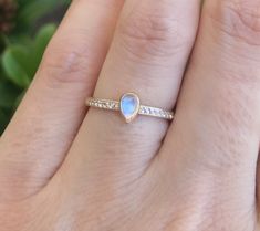 "A dainty teardrop low-profile ring featuring a cabochon iridescent mesmerizing Rainbow Moonstone accented with petite round-shaped genuine white topaz half-way around the shank handcrafted in your choice of 10k, 14k or 18k Solid Gold. Wrapped in a Box ready for proposing to your love one or gift-giving. This listing is for 1 Ring. Instagram Video -------------------- https://www.instagram.com/p/B1FSxiChJxZ/?igshid=9mghw4hdcjm7 Ring Info ----------------- *Cabochon Teardrop Moonstone *10k,14k or Teardrop Moonstone Promise Ring, Teardrop Moonstone Ring, Dainty Promise Ring, Gold Anniversary Rings, Gold Anniversary, Promise Rings For Her, June Birthstone, Wedding Dresses Unique, June Birth Stone