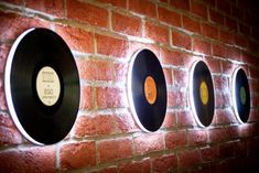 three black and white records on a brick wall