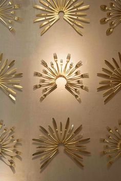 six golden sunbursts on a white wall with light coming from the top