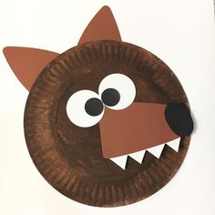 a paper plate shaped like a dog's head with big eyes and teeth on it