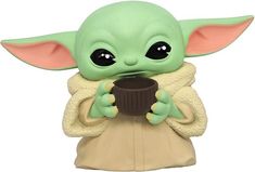 a baby yoda figurine holding a cup of coffee