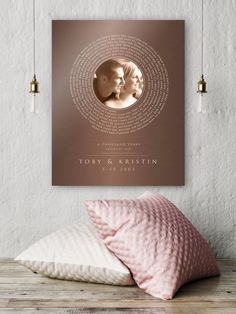 a pink pillow sitting on top of a wooden table next to a wall mounted poster