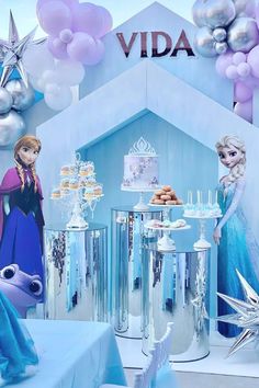 a frozen princess themed birthday party with balloons and cake table decorations, including an ice queen figure