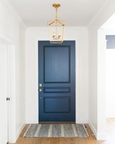 a blue door with a light fixture hanging from it's ceiling in an empty room