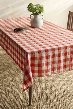 a red and white checkered table cloth with a potted plant on it