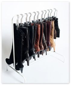 a rack with several pairs of boots hanging from it's sides and on the side