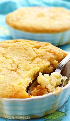 a close up of a pie in a bowl with a spoon on a table next to water